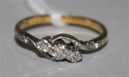 An 18ct gold, platinum and illusion set three stone diamond ring, with diamond set shoulders, size M.
